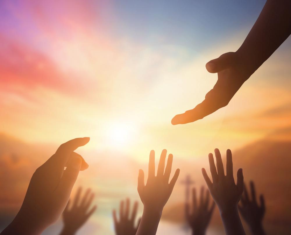 Several hands reaching for a helping hand
