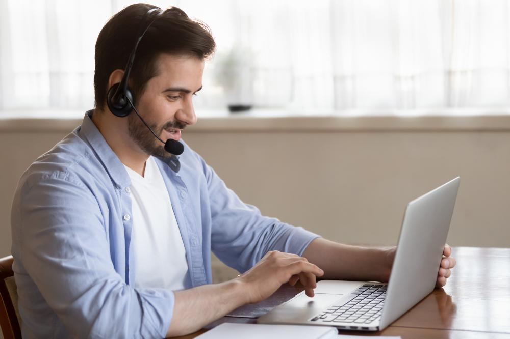 webinar-dqs-junger-mann-mit-headset-sitzt-vor-einem-laptop
