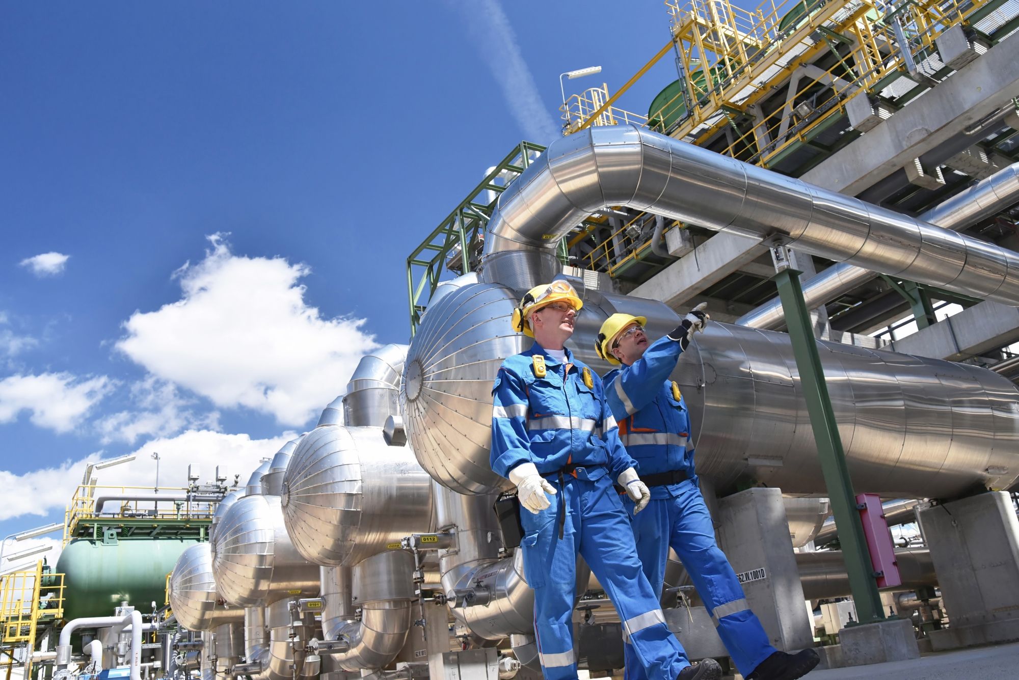 Two workers walking in a petrochemical plant